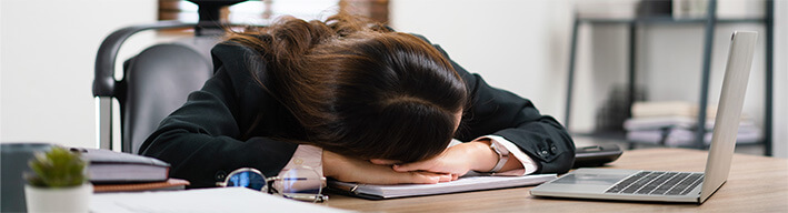 机に伏せている女性